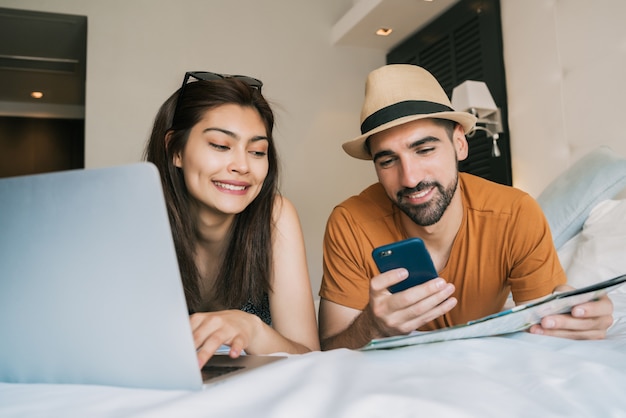 Pareja Organizando Su Viaje En La Habitacin Del Hotel Foto Premium