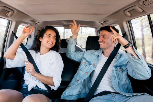 Pareja de tiro medio bailando dentro del coche Foto gratis