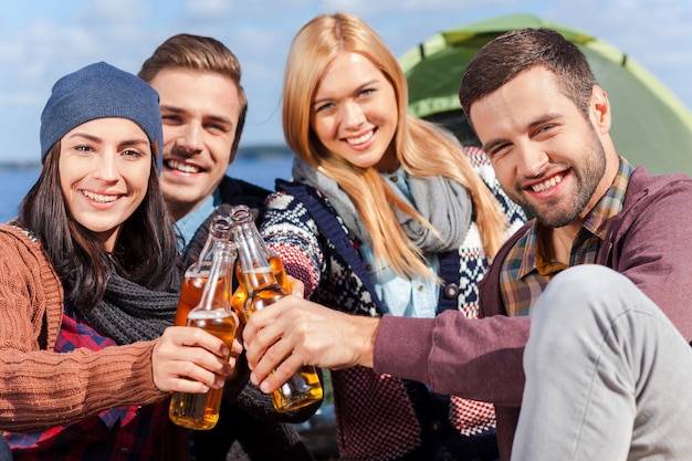 Pasar Un Buen Rato Con Amigos Cuatro Jóvenes Felices Animando Con Cerveza Y Sonriendo Mientras