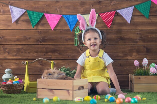 Pascua de resurrección niña en orejas de conejo de pascua con huevos