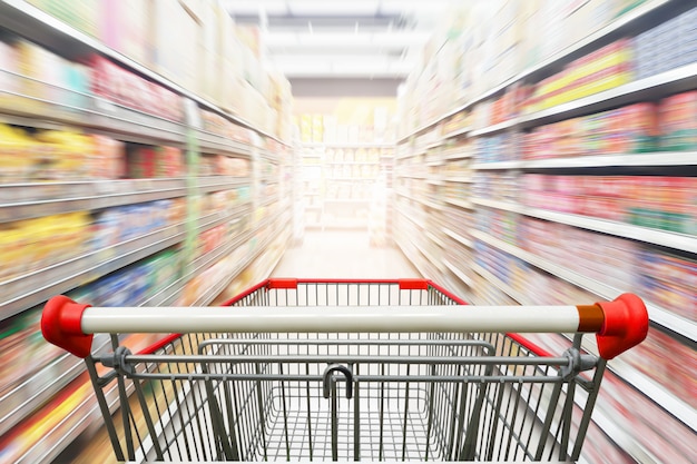 Pasillo del supermercado con carrito de compras rojo vacío Foto Premium