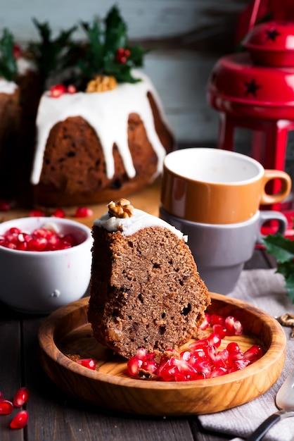 Pastel De Chocolate Cliche De Navidad Con Glaseado Blanco Y Granos De Granada En Una Madera Oscura Tazas Y Decoraciones Foto Premium