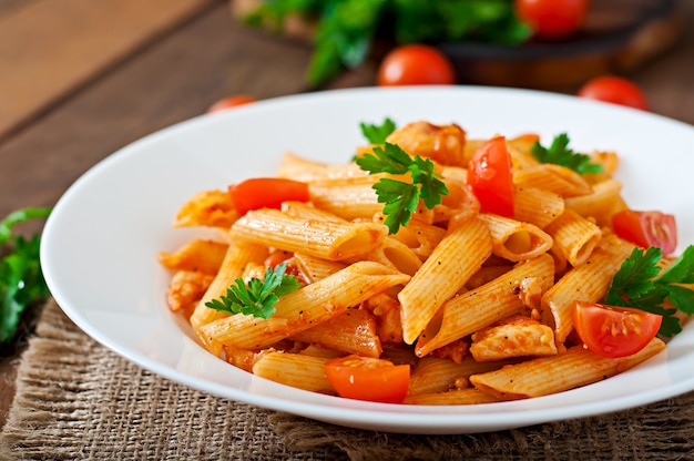 Penne Pasta En Salsa De Tomate Con Pollo Y Tomates En Una Mesa De Madera Foto Premium 0258