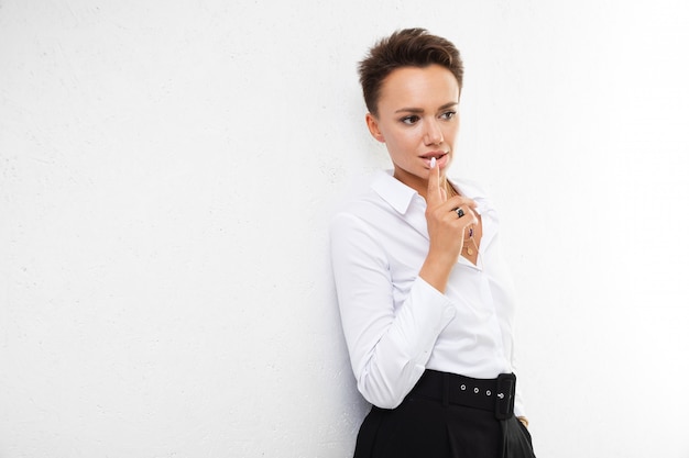 Pensando en la chica de pelo corto con una camisa blanca Hermosa mujer llevando una camisa blanca grande con cuello