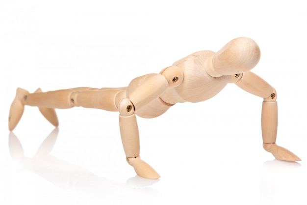 Pequeño muñeco de madera durante las flexiones Foto Premium