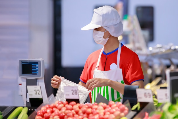 Personal de supermercado en máscara protectora médica trabajando en supermercado Foto Premium 