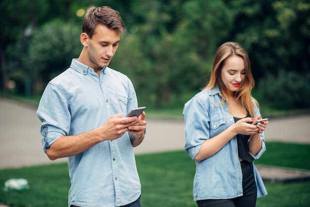 Personas Adictas Al Teléfono Pareja En El Parque De Verano Hombre Y Mujer Usando Sus Teléfonos 4929