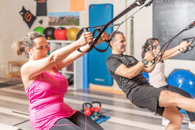 Personas Que Hacen Ejercicios Con Correas De Fitness Trx En El Gimnasio