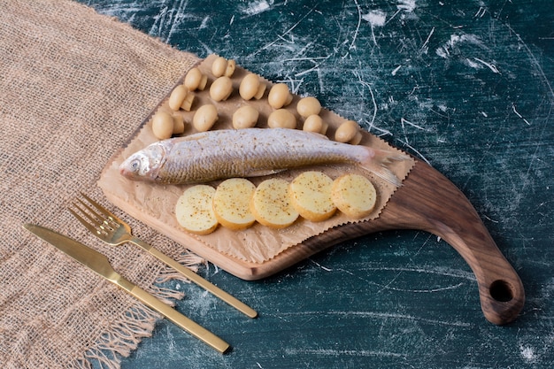 Pescados Enteros Crudos Con Aceitunas Y Rodajas De Patata Hervida Sobre