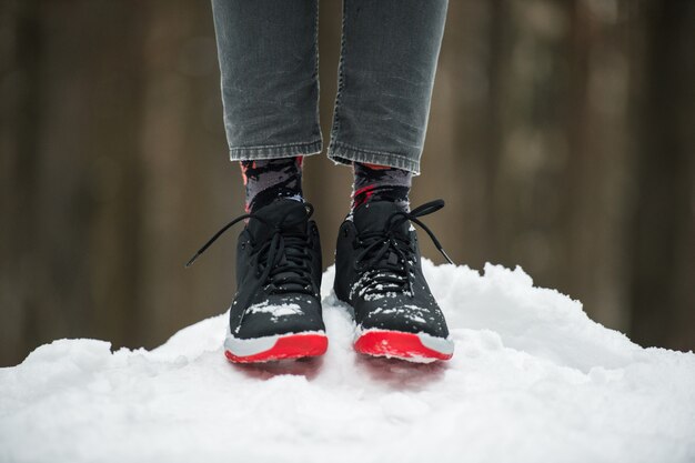 Piernas Masculinas En Calzado Deportivo Jeans Cortos Y Calcetines De Moda De Pie Sobre La Nieve Elegante Y Moderno Look De Invierno Foto Premium