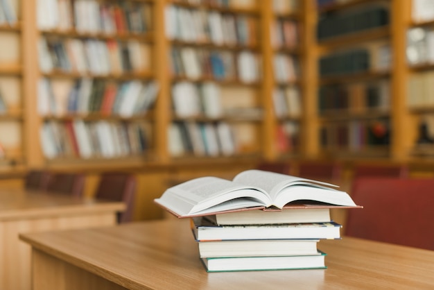 Pila de libros en el escritorio de la biblioteca