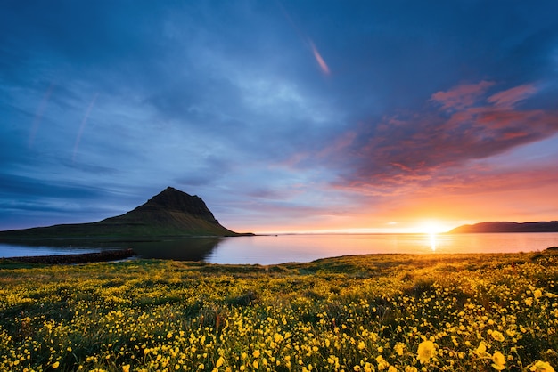 La pintoresca puesta de sol sobre paisajes y cascadas. montaña kirkjufell, islandia Foto Premium