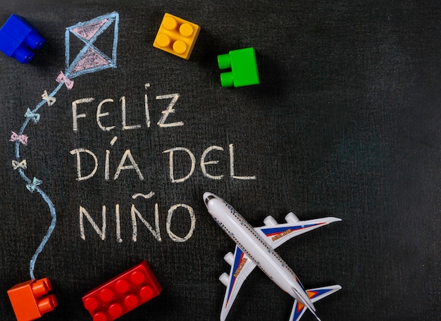 Pizarra Escrita Feliz Dia Del Nino Espanol Dibujo De Cometas Con Ensamblaje De Juguetes Y Partes De Aviones Foto Premium