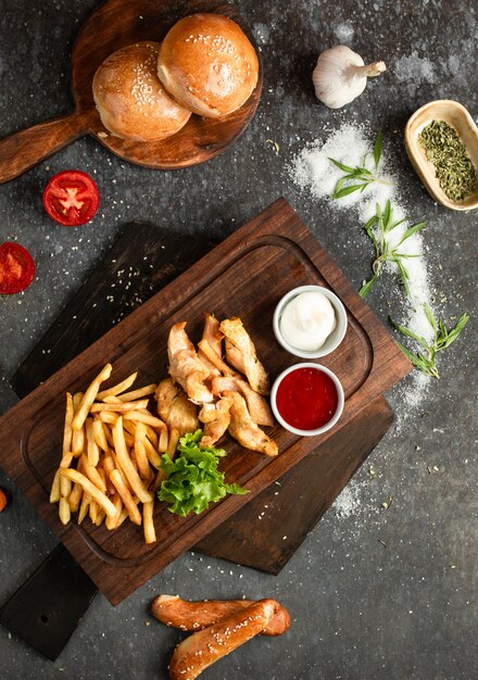 Pollo Frito Y Papas Fritas En Una Tabla De Madera Foto Gratis