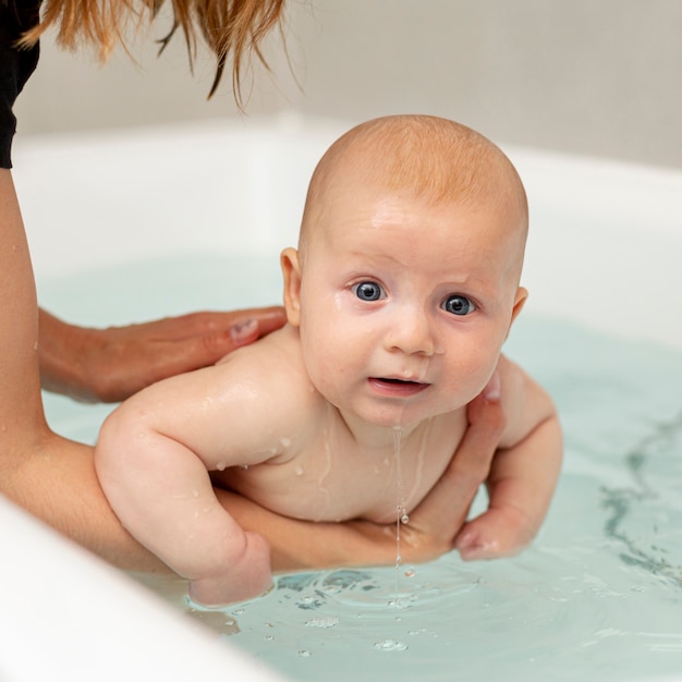 Primer bebé con ojos azules en la bañera Foto gratis