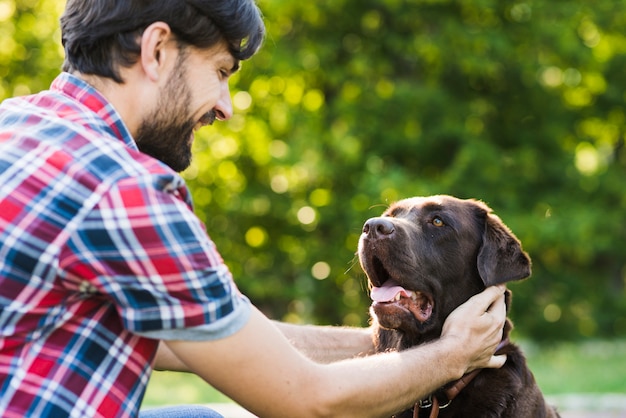 Primer Plano De Un Hombre Acariciando A Su Perro Foto Gratis 