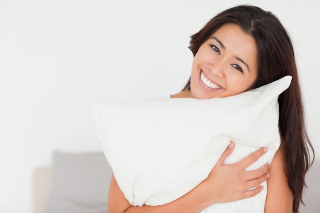 Primer Plano De Una Mujer Encantadora Con Almohada Sentada En Su Cama Mirando A Cámara Foto 8119