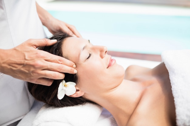 Primer plano de mujer que recibe un masaje de cabeza de masajista en un spa Foto Premium