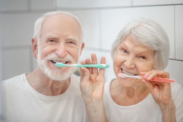 Procedimientos matutinos. pareja de ancianos cepillándose los dientes  juntos y sintiéndose bien | Foto Premium