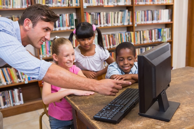 Profesor Y Alumnos Usando La Computadora En La Biblioteca Descargar