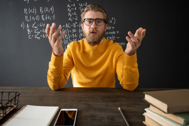 Profesor confiado de álgebra explicando un nuevo tema a sus estudiantes