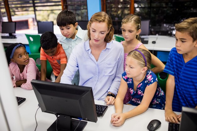 Profesor dando clase a sus alumnos con computadora pc | Foto Premium