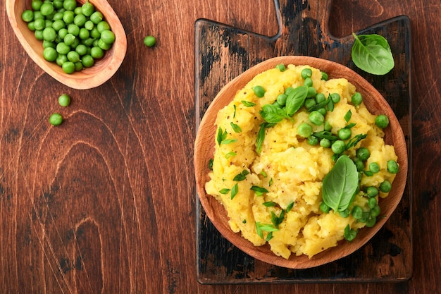 Puré de patatas con mantequilla guisantes cebollas albahaca sobre un