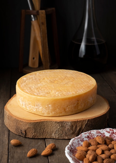 Queso Artesanal Y Almendras Sobre Una Tabla De Madera Con Botella De Vino Foto Premium