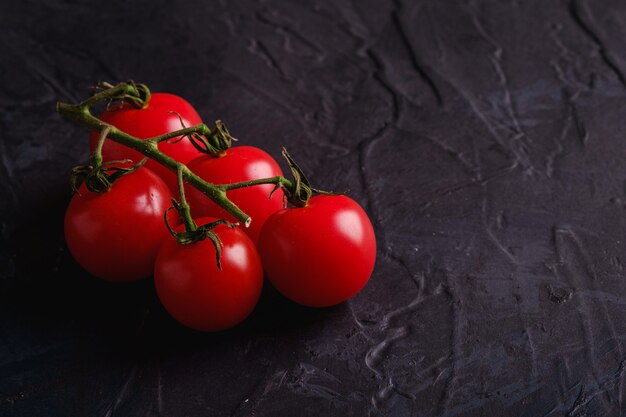 Rama de tomate cherry vegetales orgánicos maduros frescos en la pared