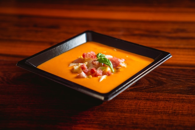 Receta Típica Española De Salmorejo Cordobés En Un Plato Cuadrado Sobre Una Mesa De Madera 9295