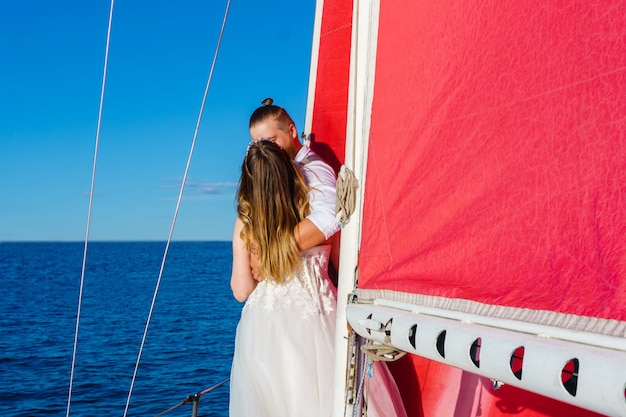 Recién casados en un viaje de bodas al mar en un yate de vela | Foto