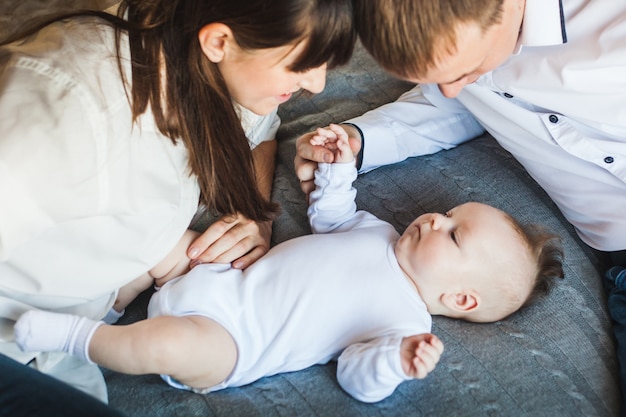 Recien Nacido Acostado En La Cama Mama Mira A Su Bebe Papa Mira A Su Bebe Nino Pequeno Foto Premium