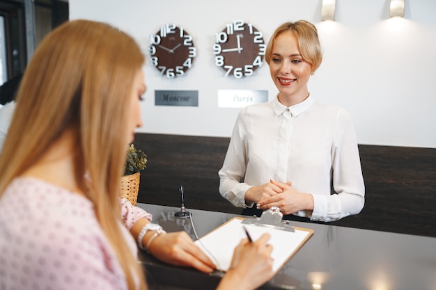 Registro De Huéspedes De Hotel Mujer Rubia En La Recepción Del Hotel Foto Premium 7346