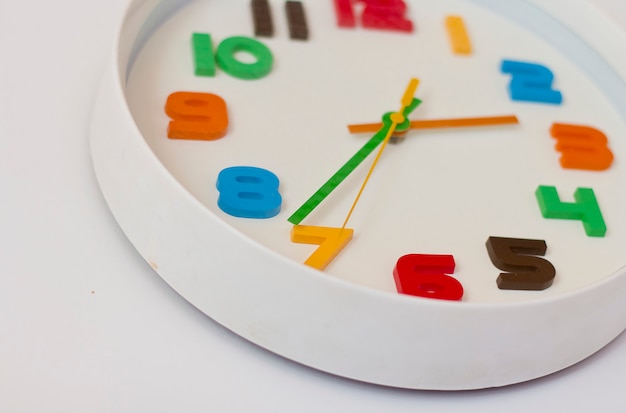 Reloj de pared blanco con números de colores. reloj de Reloj de pared blanco con números de colores. reloj de