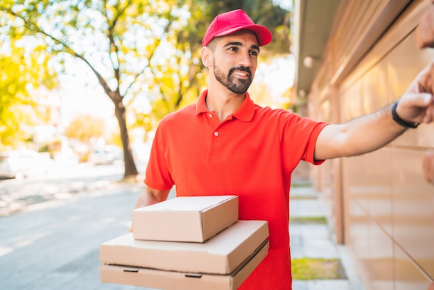 Repartidor Con Caja De Pizza Tocando El Timbre De La Casa Foto Premium