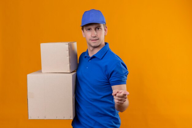 Repartidor Guapo Joven En Uniforme Azul Y Gorra Sosteniendo Cajas De