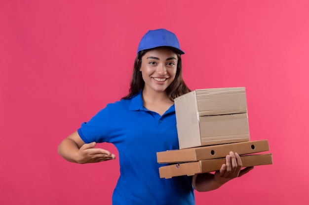 Repartidor Joven En Uniforme Azul Y Gorra Sosteniendo Cajas De Pizza Y