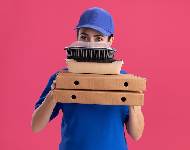 Repartidor Joven En Uniforme Y Gorra Sosteniendo Paquetes De Pizza Con Paquete De Comida De 6803