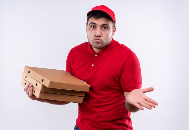 Repartidor Joven En Uniforme Rojo Y Gorra Sosteniendo Cajas De Pizza