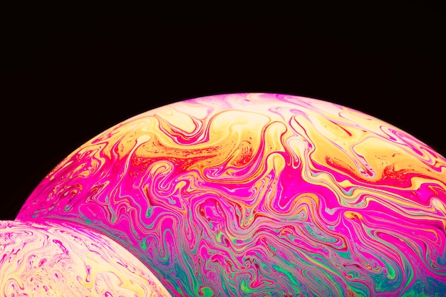 Resumen burbujas de jabón psicodélico multicolor sobre fondo negro Foto gratis