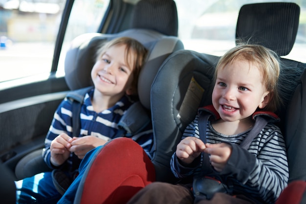 Retrato De Chicos Guapos Sentados En Los Asientos Del Coche Seguridad En El Transporte De Ninos Foto Premium