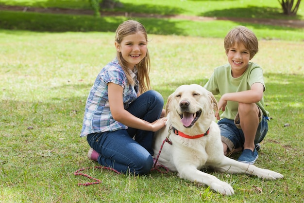 Retrato de niños jugando con perro mascota en el parque Descargar Fotos premium