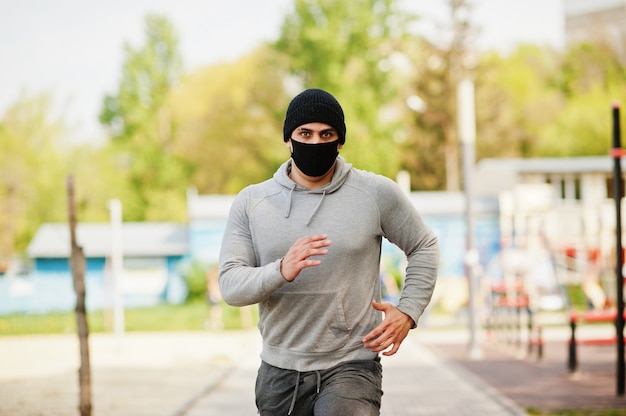 Retrato deportes hombre árabe en negro mascarilla médica correr al aire  libre durante la cuarentena de coronavirus. | Foto Premium