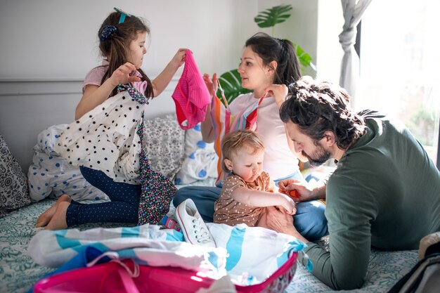 Retrato de familia con dos pequeñas hijas de embalaje para vacaciones