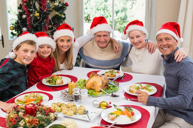 Retrato De Familia Sonriente Sentados Juntos En La Cena De Navidad Foto Premium 