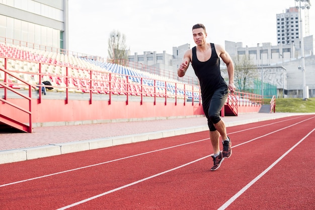 Retrato De Fitness Joven Atleta Masculino Corriendo En La Pista De