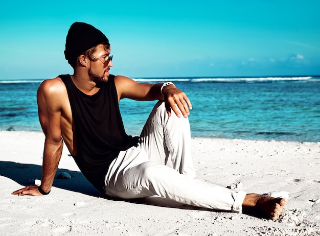 Retrato de guapo hipster tomar el sol modelo de moda con ropa casual en