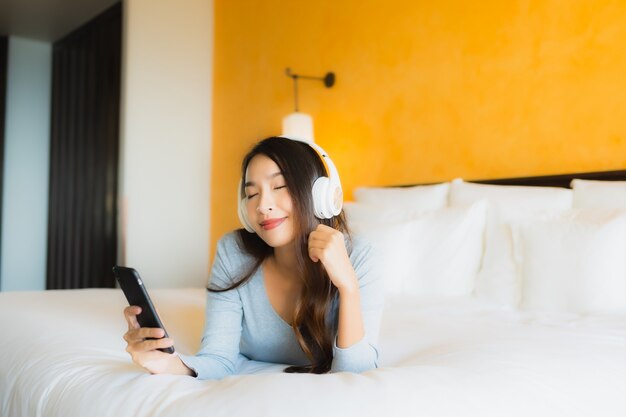 Retrato Hermosa Joven Asiática Con Teléfono Celular Móvil Con Auriculares Para Escuchar Música 5908