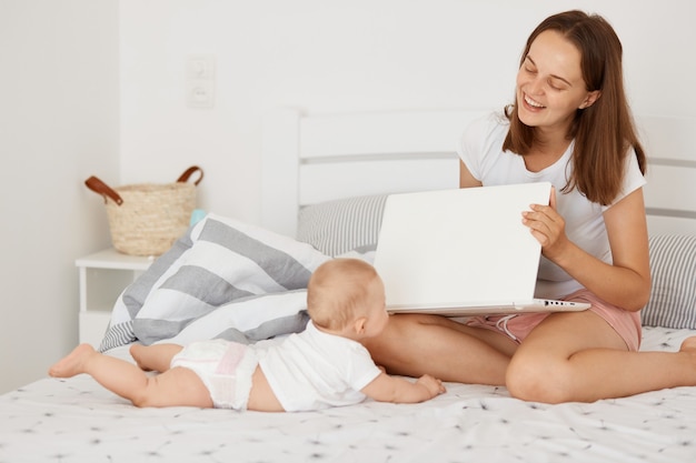 Retrato de hermosa mujer alegre sonriente con bebé recién nacido