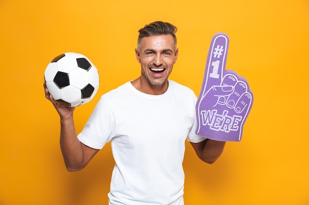 Retrato de hombre hermoso de 30 años en camiseta blanca sosteniendo un